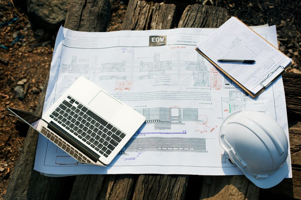 Computer, hard hat, and construction information on a table